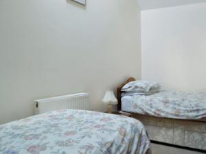 ein Schlafzimmer mit 2 Betten und einer Lampe in der Unterkunft Daisy Cottage in Chipping Sodbury