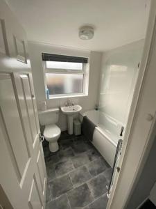 a bathroom with a toilet and a tub and a sink at Seaside 2 bed Townhouse, near Cleethorpes station in Cleethorpes