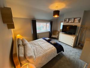 a bedroom with a large bed and a television at Seaside 2 bed Townhouse, near Cleethorpes station in Cleethorpes
