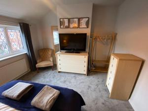 1 dormitorio con 1 cama, TV y vestidor en Seaside 2 bed Townhouse, near Cleethorpes station, en Cleethorpes