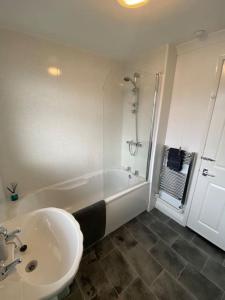 a white bathroom with a sink and a shower at Seaside 2 bed Townhouse, near Cleethorpes station in Cleethorpes