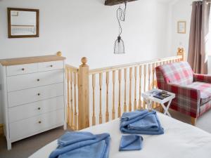 a baby bedroom with a crib and a chair at Riverbank Cottage in Kirkby Stephen