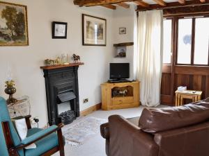 a living room with a couch and a fireplace at Swallows Nest - E3245 in Crackenthorpe