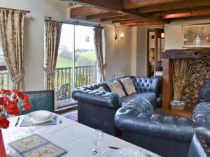 a living room with blue leather furniture and a table at The Peat House in Soutergate