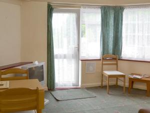 Stokeinteignhead的住宿－Ashbury Tor - Ukc1922，客房设有电视、椅子和窗户。