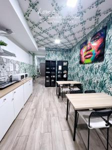 una habitación con mesas y una pared con una pintura en HOSTEL H8 en Madrid