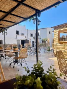 patio z krzesłami, stołami i sprzętem do grillowania w obiekcie Hôtel Restaurant La Caravelle w mieście Sari-Solenzara