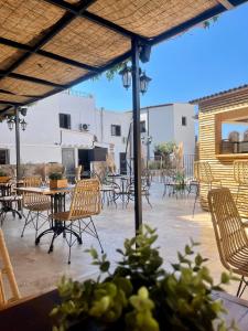 an outdoor patio with chairs and tables and a grill at Hôtel Restaurant La Caravelle in Sari Solenzara