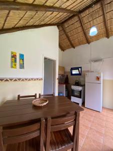 una sala da pranzo con tavolo e frigorifero di Cabañas Giramundos a Punta Del Diablo