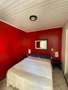 a red bedroom with a bed with a red wall at Tao in Búzios