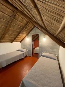 een zolderkamer met 3 bedden. bij Cabañas Giramundos in Punta Del Diablo