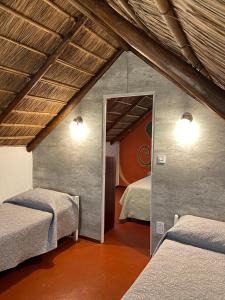 Habitación con 2 camas y espejo. en Cabañas Giramundos en Punta del Diablo