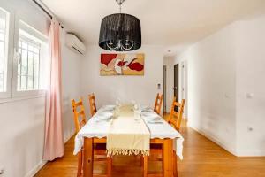 une salle à manger avec une table, des chaises et un lustre dans l'établissement Modern design apartament in Conil!, à Conil de la Frontera