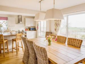 a kitchen and dining room with a wooden table and chairs at Lodge Farmhouse in Scarborough