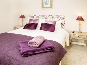 a bedroom with a bed with purple towels on it at Lodge Farmhouse in Scarborough