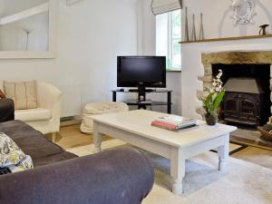 a living room with a coffee table and a fireplace at The Downs Barn Lodge in Nailsworth