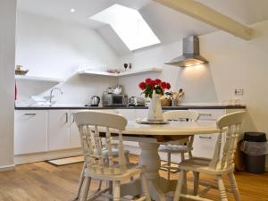 a kitchen with a table and chairs in a room at The Downs Barn Lodge in Nailsworth