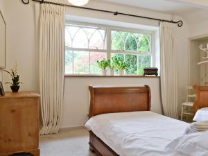 sypialnia z łóżkiem i oknem w obiekcie The Downs Barn Lodge w mieście Nailsworth