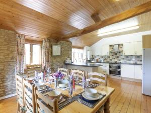 uma cozinha e sala de jantar com uma mesa de madeira e cadeiras em The Mill House em Lea