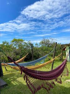 una hamaca en el césped en un campo en Cabañas Giramundos en Punta del Diablo