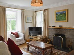 a living room with a fireplace and a tv at Straitinnan in Haugh of Glass