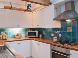 a kitchen with white cabinets and a stove top oven at Piglets Place - E4300 in Halston