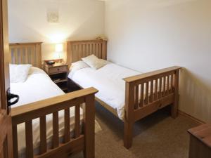 a bedroom with two beds and a night stand with a bedsenalsenalsenalsenal at Piglets Place - E4300 in Halston