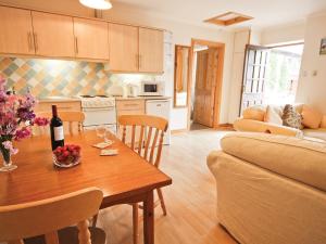 a kitchen and living room with a table with a bottle of wine at Bridle Cottage in Hoarwithy