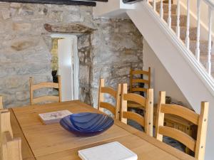 ein Esszimmer mit einem Holztisch und einer Treppe in der Unterkunft Pendref in Trawsfynydd