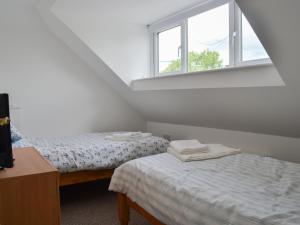two twin beds in a room with a window at Rhos Y Grug in Llangwnadl