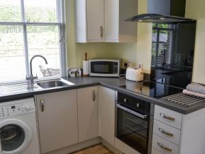 a kitchen with a sink and a stove top oven at The Waiting Rooms in Cawston