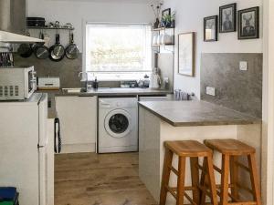 a kitchen with a sink and a washing machine at Beach Cottage in Gairloch