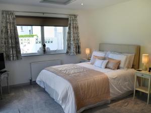 a bedroom with a large bed and a window at Little Tamarisk in Padstow