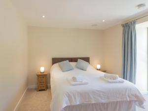 a bedroom with a white bed with two towels on it at Property 1 in Wroxall