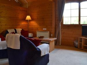 a living room with a couch and a table and a tv at The Cabin in Wendling