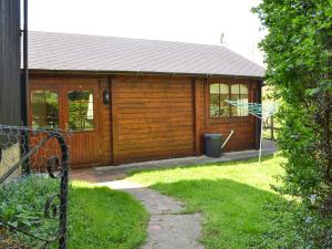 eine Holzhütte mit einer Tür und einem Hof in der Unterkunft The Cabin in Wendling