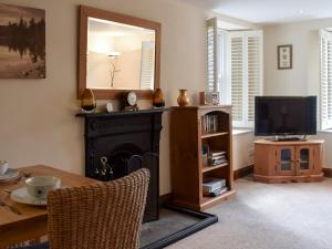 a living room with a fireplace and a television at Church View in Ambleside