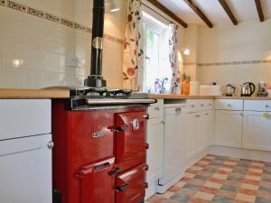 a kitchen with an old red stove in it at Maes-yr-adwy in Abergorlech