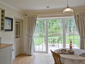 a kitchen and dining room with a sliding glass door at Curlew Cottage in Meigle