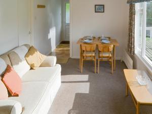 a living room with a couch and a table at Silver Birches-af46 in Horning