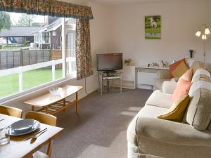 a living room with a couch and a tv at Silver Birches-af46 in Horning