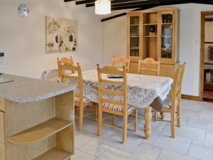 uma cozinha com mesa e cadeiras e um balcão em The Old Piggeries em Loders