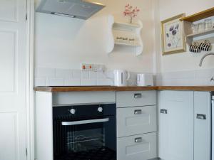 a kitchen with white cabinets and a counter top at The Cider Barn in Presteigne