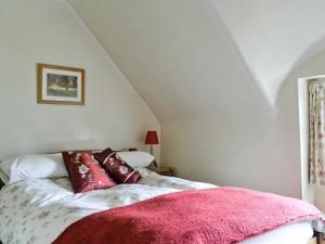 a bedroom with a bed with a pink blanket at Rose Cottage in Chipping Campden