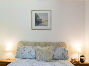 a bedroom with a bed with a picture on the wall at Squirrel Cottage in Kilmuir