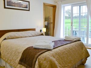 a bedroom with a bed with two towels on it at Ty-canol in Ferryside