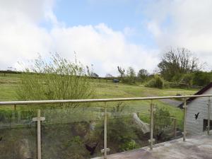 uma vista para um campo a partir da varanda de uma casa em Ty-canol em Ferryside