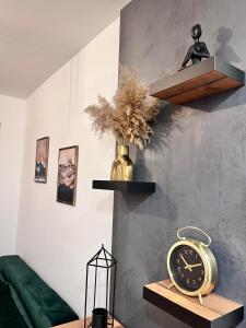 een klok zittend op een tafel in een kamer bij Zlatiborika Spa&Lux Apartment in Zlatibor