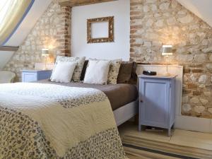 a bedroom with two beds and a stone wall at The Granary in Oxborough