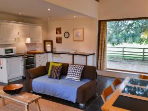 un soggiorno con divano e una cucina di The Granary a Oxborough